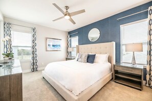 A bedroom with a bed, a ceiling fan, a bedside table, and a window with blinds. - Bright and Sunny Townhouse With Games Room at Reunion (Kissimmee)