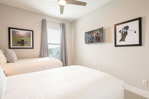 A hotel room with two beds, a ceiling fan, and three framed pictures on the walls. - Bright and Sunny Townhouse With Games Room at Reunion (Kissimmee)