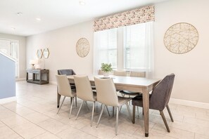 A dining area with a table, chairs, and a potted plant. - Dashing Villa With Games Room at Encore (Kissimmee)