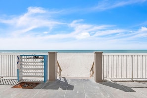 Blick auf einen Strand mit einem weißen Zaun und einem Schuhregal.