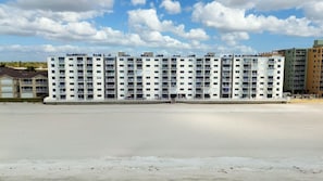 Ein mehrstöckiges Hotel mit Balkonen in Strandnähe.
