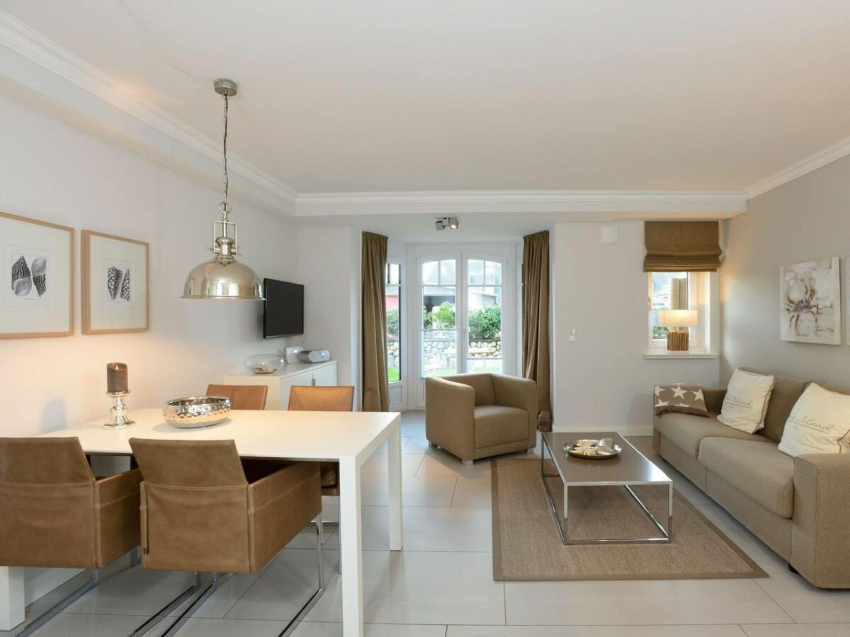 A modern living room with a dining area, a sofa, a coffee table, and a television.