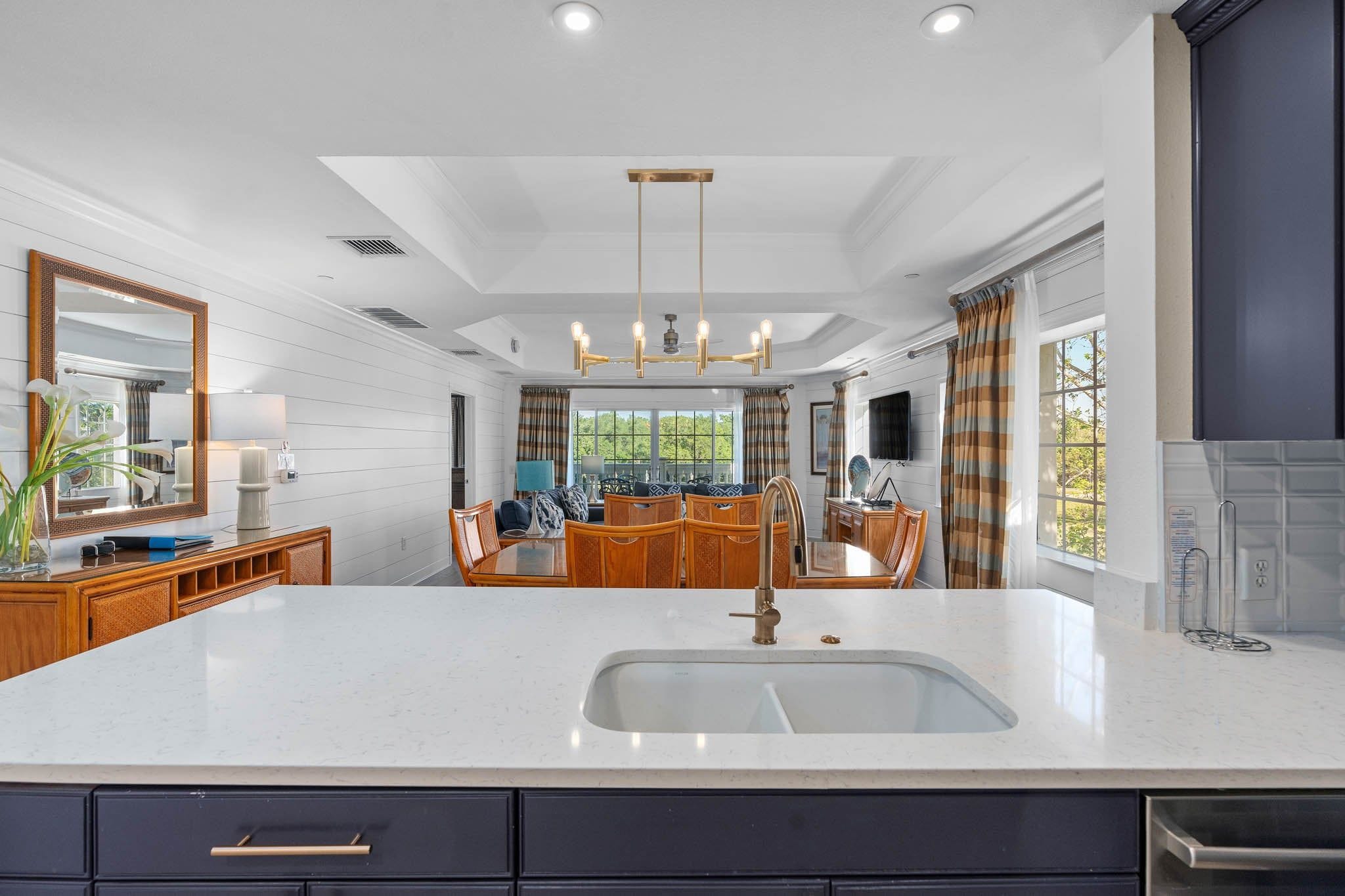 A modern kitchen with a large island, built-in appliances, and a view to the outdoors.