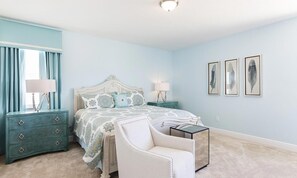 A bedroom with a bed, nightstands, a chair, and framed artwork on the wall. - Lively Home With Galactic Themed Bedroom at Encore (Kissimmee)