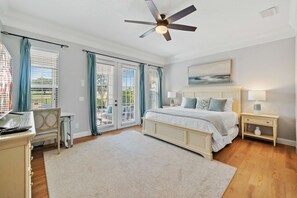 A bedroom with a bed, bedside tables, a ceiling fan, and a view through the window. - Polished Villa With Home Theater at Reunion (Kissimmee)