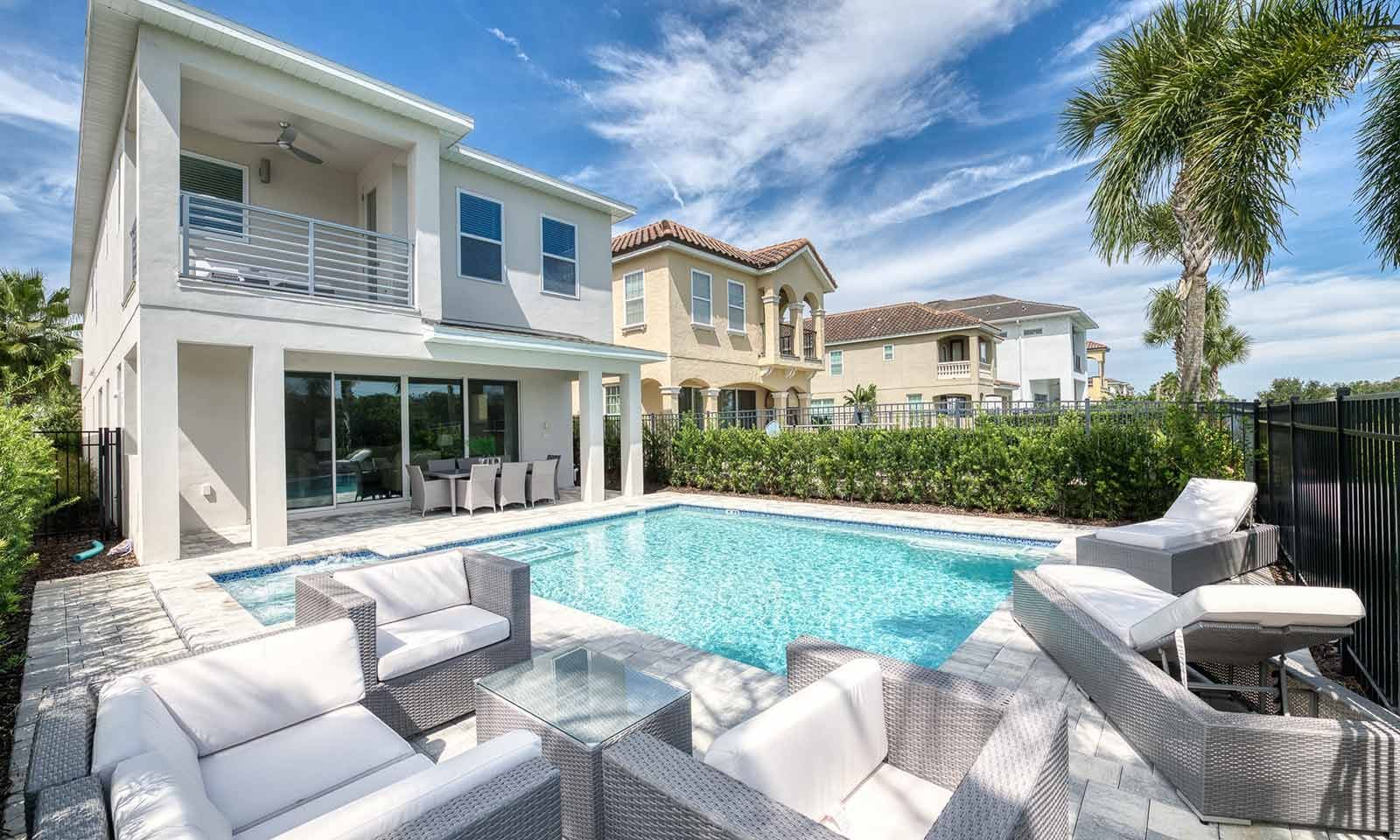 A modern house with a swimming pool, outdoor furniture, and a well-maintained garden.