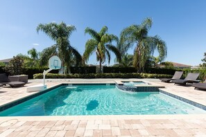 A swimming pool with a basketball hoop, lounge chairs, and palm trees. - Luxurious Villa With Tiki Themed Game Room at Encore (Kissimmee)