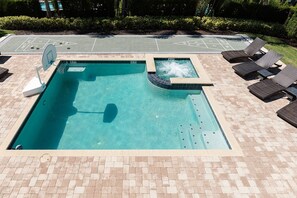 A swimming pool with a hot tub, lounge chairs, and a shuffleboard court. - Luxurious Villa With Tiki Themed Game Room at Encore (Kissimmee)