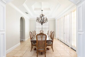 A dining room with a chandelier, wooden chairs, and a large table. - Happy Abode With Annex at Reunion (Kissimmee)
