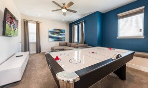 A room with a pool table, a ceiling fan, a sofa, and a painting on the wall. - Modern Villa With Private Pool in Encore (Kissimmee)