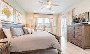 A bedroom with a bed, a nightstand, a dresser, a ceiling fan, and a TV. - Sun-kissed Villa With Private Pool at Encore (Kissimmee)