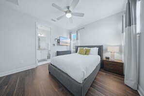 A bedroom with a bed, nightstand, and ceiling fan. - Orlando Luxury Home With Pool Heat Included (Kissimmee)
