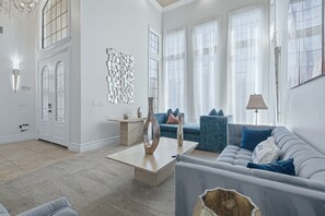 A modern living room with a sofa, coffee table, and decorative items. - Upscale Oasis With Home Theater at Reunion (Kissimmee)