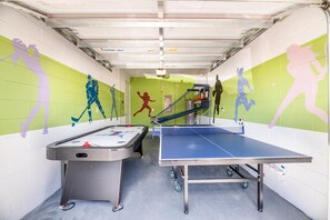 Ein Innenbereich mit Erholungsangeboten, darunter ein Kicker, ein Tischtennisplatte und ein kleiner Basketballkorb.