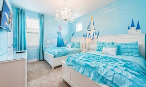 Ein Schlafzimmer mit einem großen Bett, einem kleineren Bett, einer Kommode und einem Nachttisch.