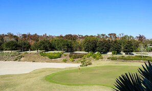 Um campo de golfe com bunkers de areia, putting green e haste de bandeira.