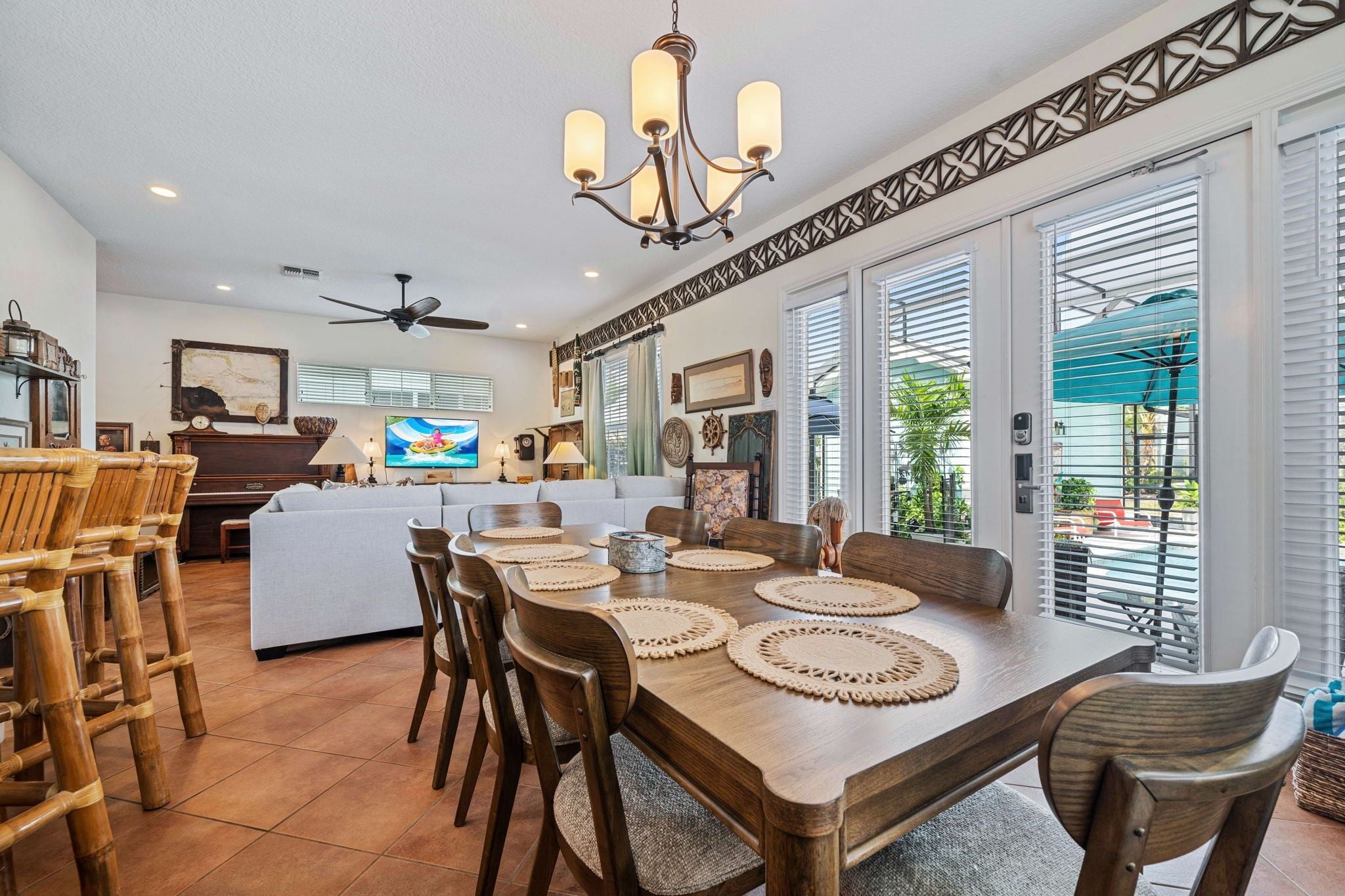 A spacious dining area with a wooden table, chairs, and a ceiling fan.