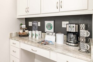 A kitchen counter with a coffee maker, a Wi-Fi sign, and several Starbucks cups. - Sophisticated Villa With Movie Room at Encore (Kissimmee)