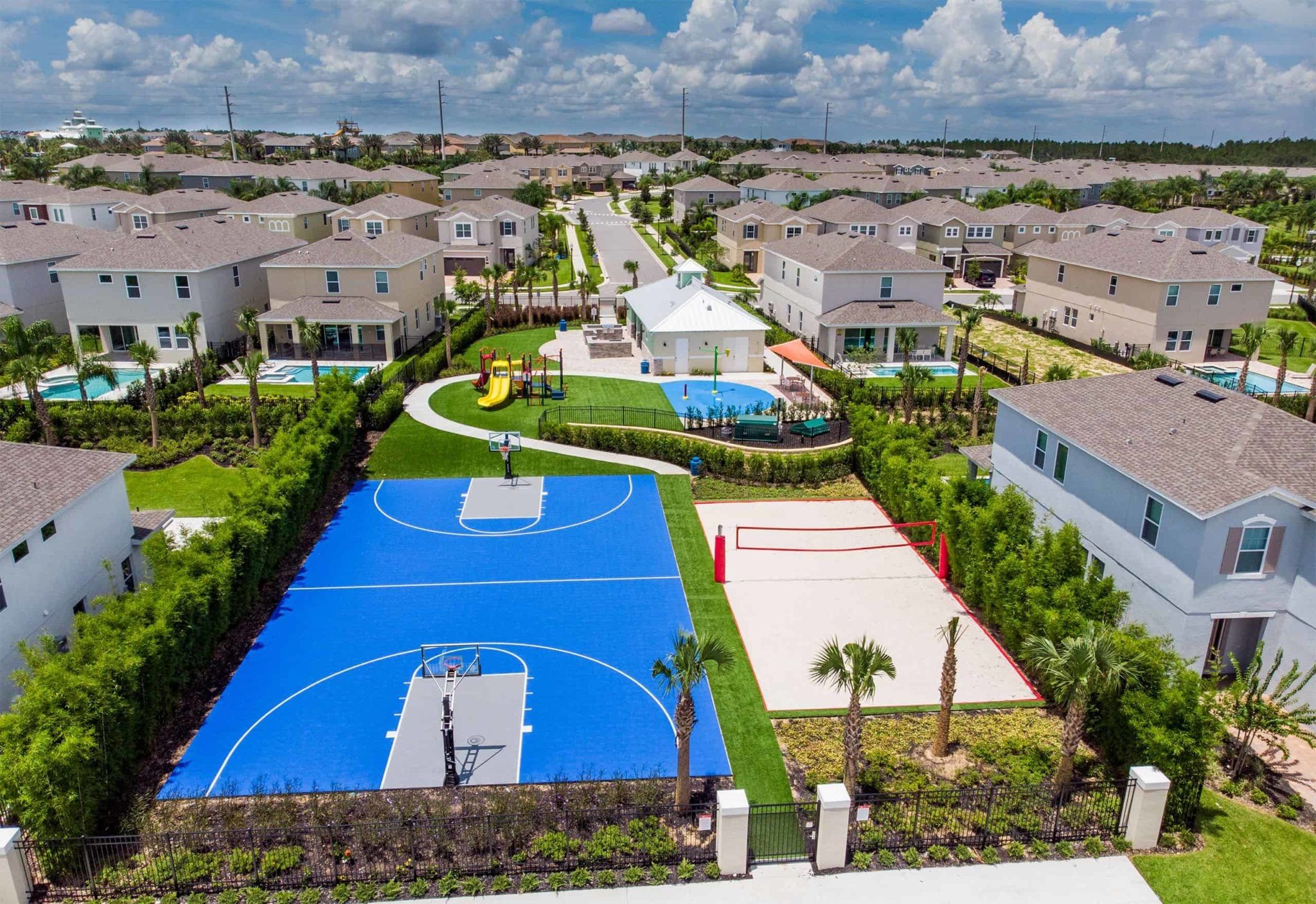 A residential area with multiple houses, a basketball court, and a swimming pool.