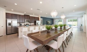A modern kitchen with a central island, stainless steel appliances, and pendant lighting. - Stylish Sleek Home With Full Kitchen at Encore (Kissimmee)