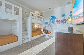 A children's room with bunk beds, a bean bag chair, a wall mural, and a television. - Sun-filled Haven With Sports Themed Game Room at Reunion (Kissimmee)