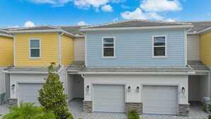 A row of townhouses with two garages and a small front yard. - Getaway Townhome at Reunion Resort (Kissimmee)