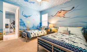 A bedroom with a mural of sea creatures, a bed, a nightstand, and a chair. - Modern Villa With Fun Themed Bedrooms at Reunion (Kissimmee)
