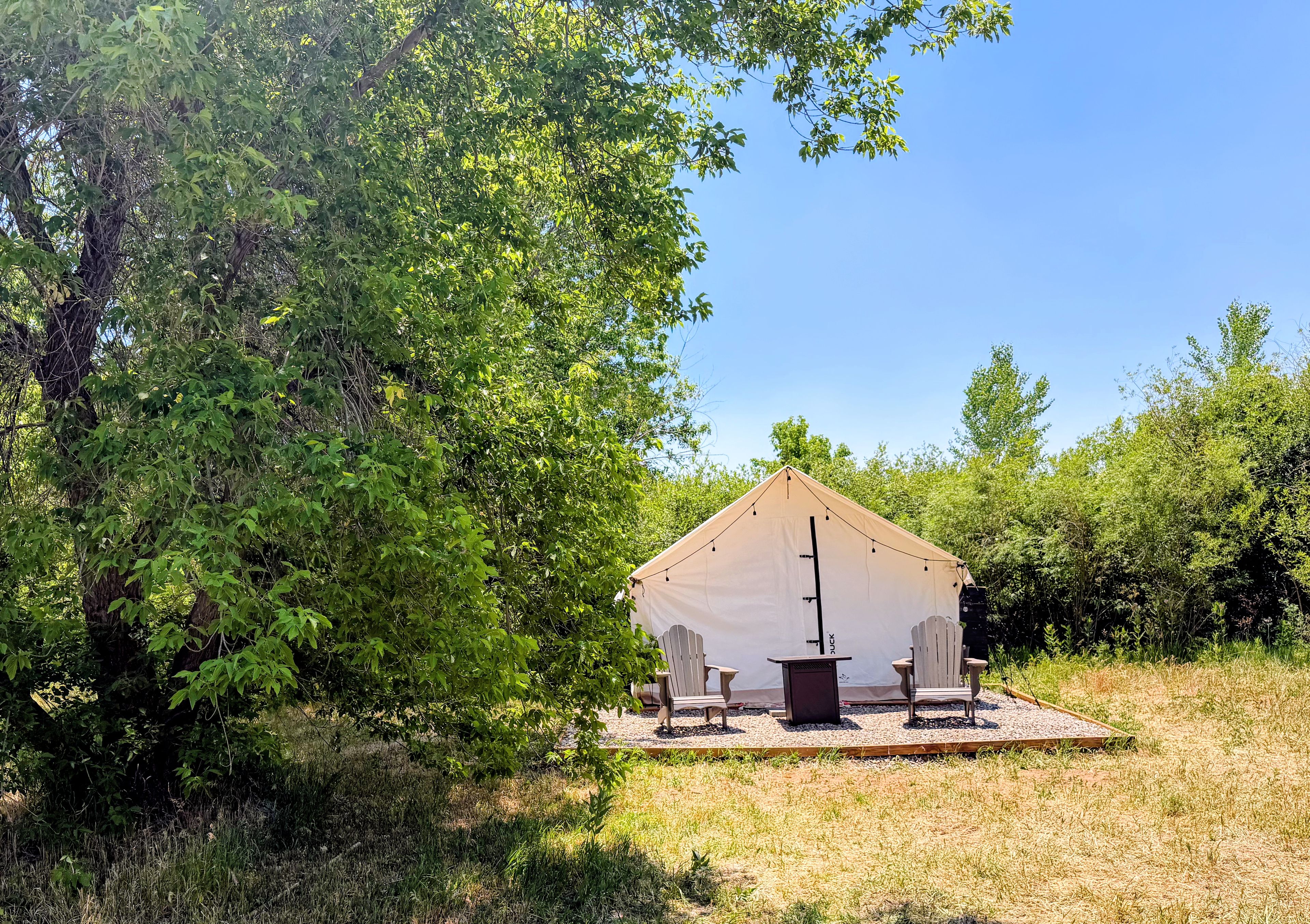 A small, single-story structure with a pitched roof, surrounded by dense greenery.