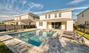 A residential pool area with a rectangular pool, lounge chairs, and a patio with a table and chairs. - Marvelous Retreat With Themed Bedrooms at Encore (Kissimmee)