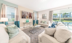 A well-lit living room with a sofa, coffee table, and a painting on the wall. - Marvelous Retreat With Themed Bedrooms at Encore (Kissimmee)