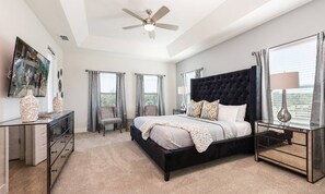 A bedroom with a large bed, a ceiling fan, a dresser, and a nightstand. - Stylish Villa With Unreal Themed Bedroom at Reunion (Kissimmee)