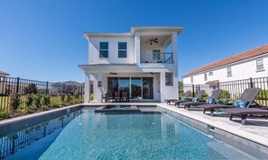 A modern two-story house with a swimming pool, outdoor seating, and a balcony. - Stylish Villa With Unreal Themed Bedroom at Reunion (Kissimmee)