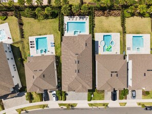 Ein Wohngebiet mit mehreren Häusern, jedes mit Swimmingpool und Garage.