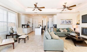 A spacious living area with a sofa set, a dining table, and a kitchen in the background. - Lively Home With Water Views at Reunion (Kissimmee)