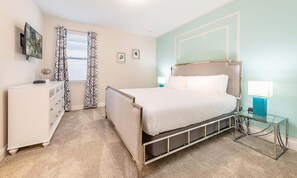Een slaapkamer met een bed, een kaptafel en een aan de muur bevestigde televisie.