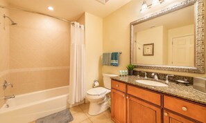 A bathroom with a bathtub, toilet, vanity with a sink, and a large mirror. - Spacious Elegant Condo With Private Balcony at Reunion (Kissimmee)