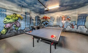 A table tennis table in a room with a mural of superheroes on the walls. - Marvelous Villa With Galactic Themed Bedroom at Encore (Kissimmee)
