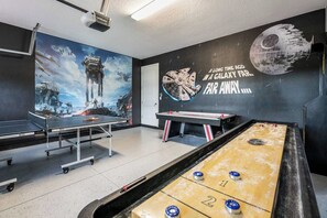 Ein Zimmer mit Tischtennisplatten, einem Kicker und einer Star Wars-Inneneinrichtung.