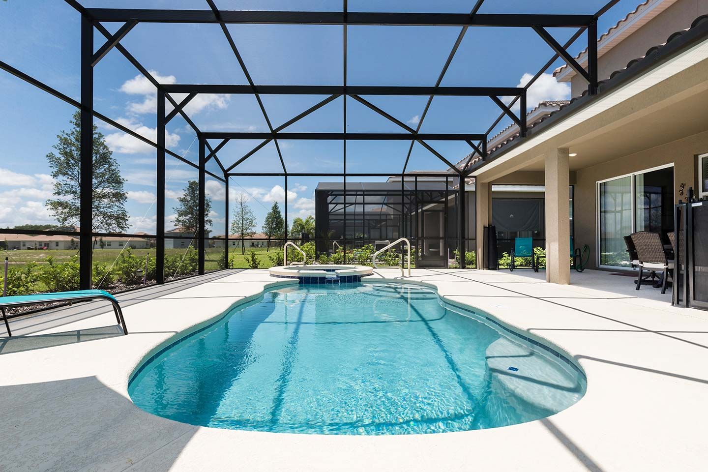 Une piscine extérieure dotée d’un espace couvert, d’un jacuzzi et d’une terrasse avec des chaises.