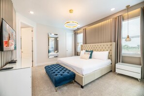 A modern hotel room with a large bed, a television, a mirror, and a view of the outdoors. - Grand Villa With Games Room at Encore (Kissimmee)