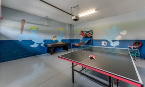 Ein Spielzimmer mit Tischfußball, Pongtisch und Basketballkorb.