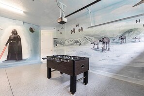 A room with a foosball table, Star Wars-themed wall art, and a Darth Vader figure. - Encore Villa: Pool & Spa, 4 Blocks to Waterpark (Kissimmee)