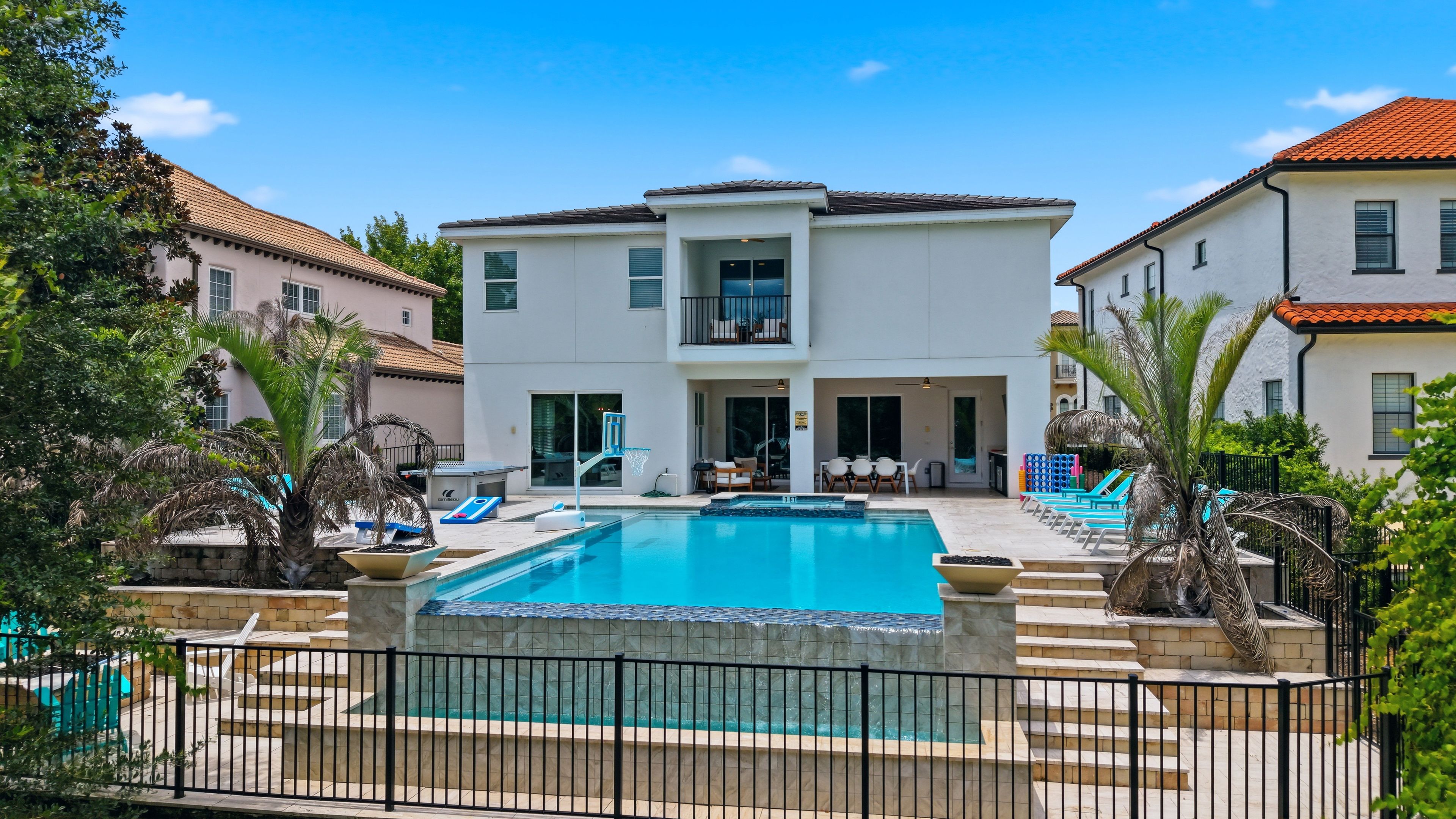 Une maison à deux étages dotée d’une piscine, d’un espace extérieur aménagé pour se détendre et d’une terrasse clôturée.