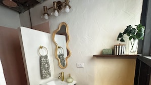 Ein kleines Badezimmer mit Toilette, Waschbecken und Spiegel.
