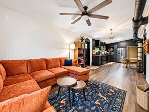 A modern living room with a sectional sofa, a round coffee table, and a patterned rug.