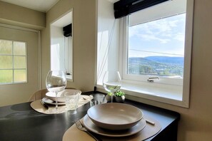 A dining table with a view of the outdoors through a window. - Morgensolen - Free Parking & Mountain Trails (bones)