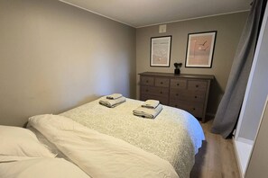 A hotel room with a bed, a dresser, and two framed pictures on the wall. - Morgensolen - Free Parking & Mountain Trails (bones)