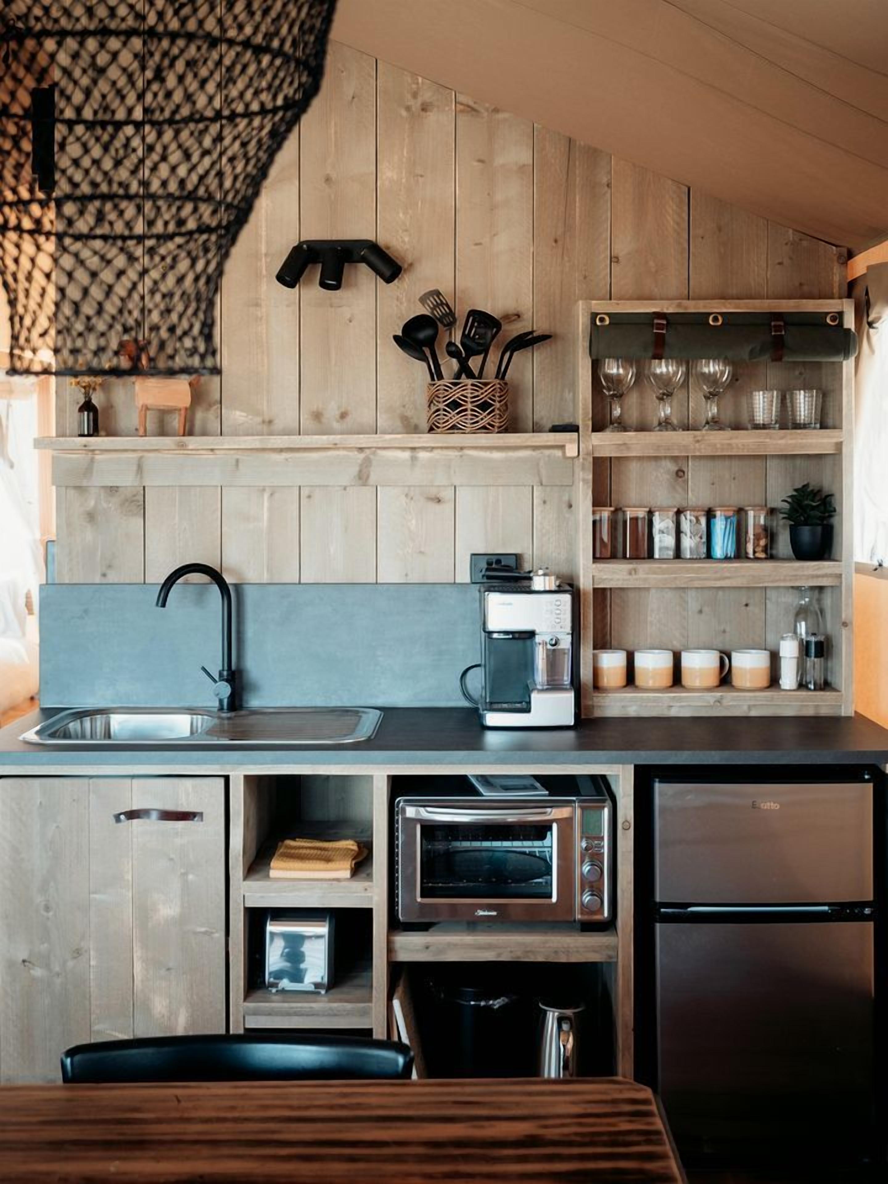 Eine kompakte Küche mit integrierter Kaffeemaschine, Toaster und Kühlschrank.