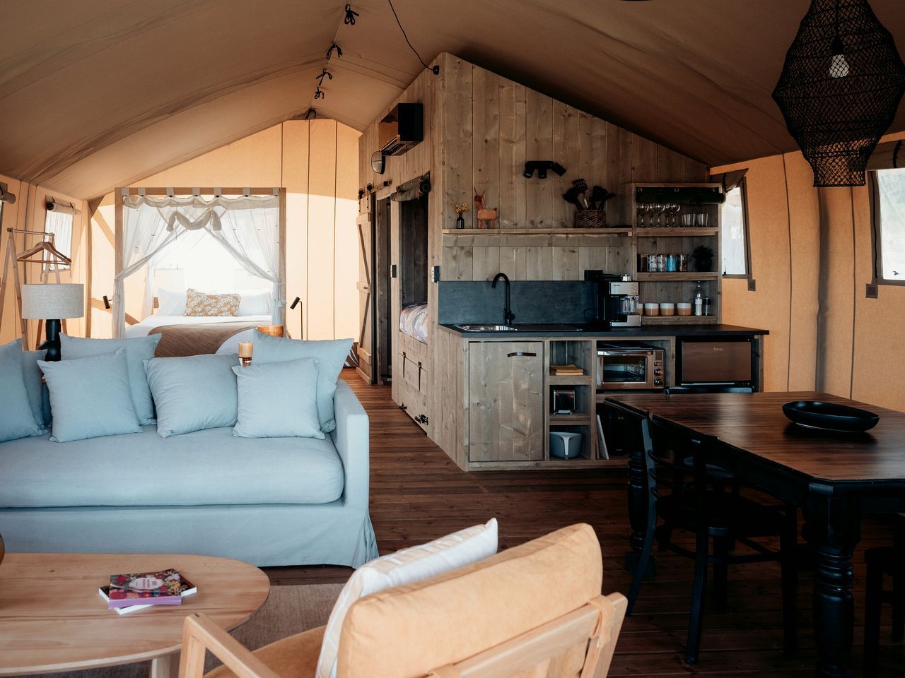 A cozy interior with a sofa, dining table, and kitchenette.
