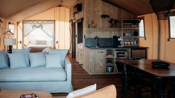 A cozy interior with a sofa, dining table, and kitchenette.